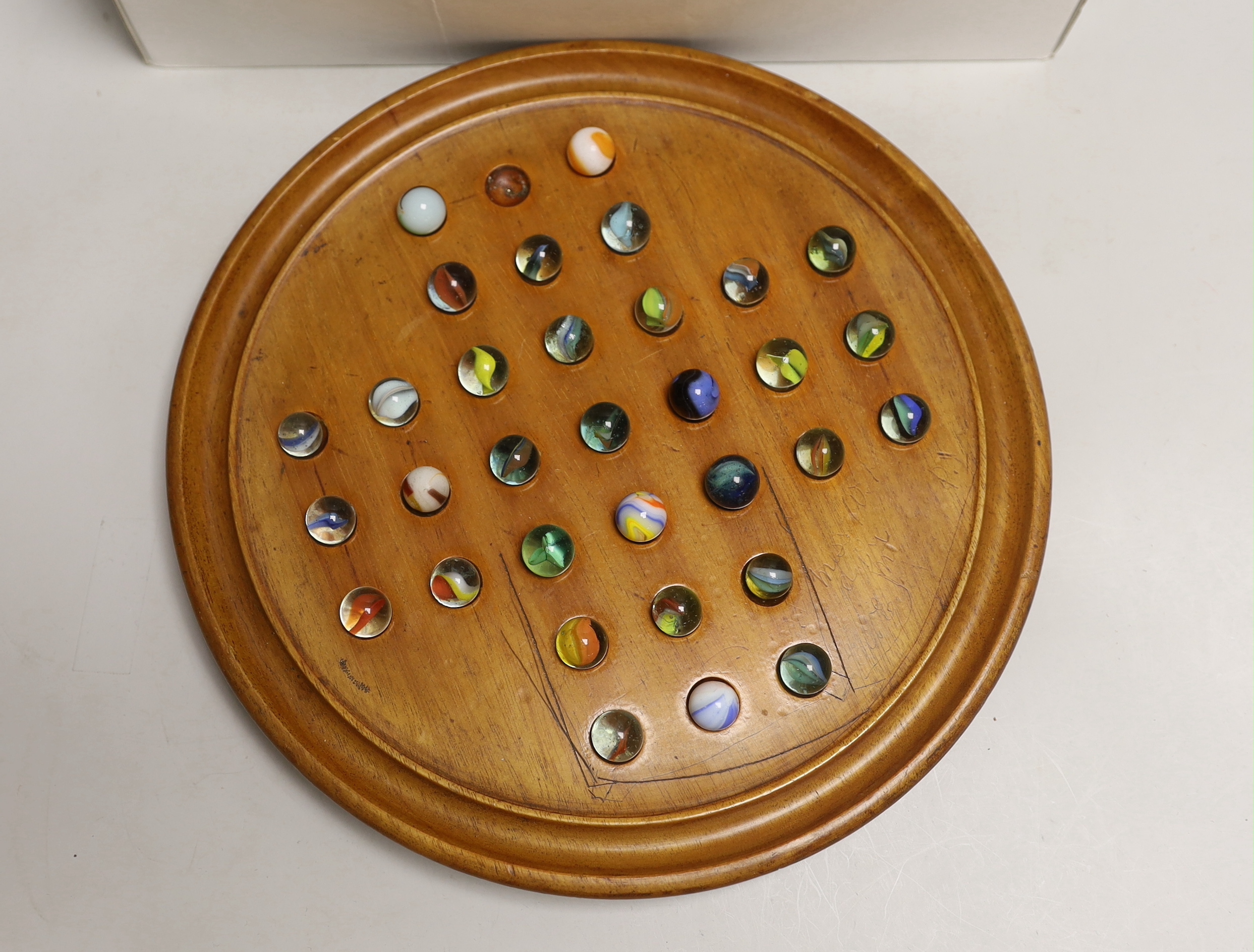 A solitaire board and a large collection marbles